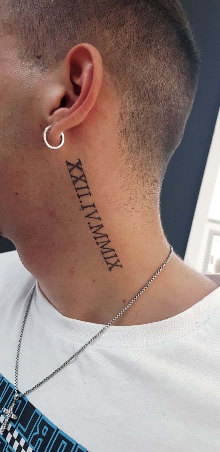 a man with a small tattoo on his neck