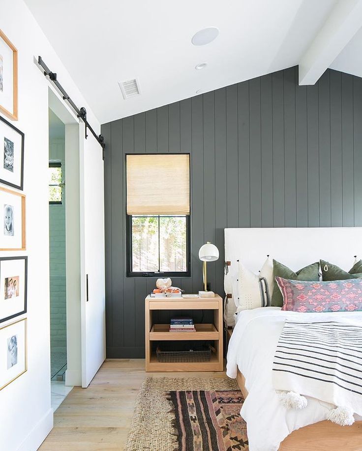 a bed room with a neatly made bed and pictures on the wall