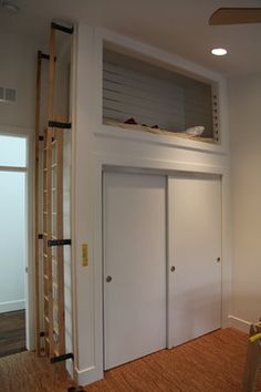 an empty room with white walls and wooden flooring in the middle, there is a ladder leading up to a loft bed