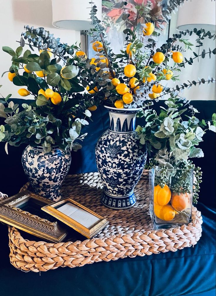 two blue and white vases with lemons on a table