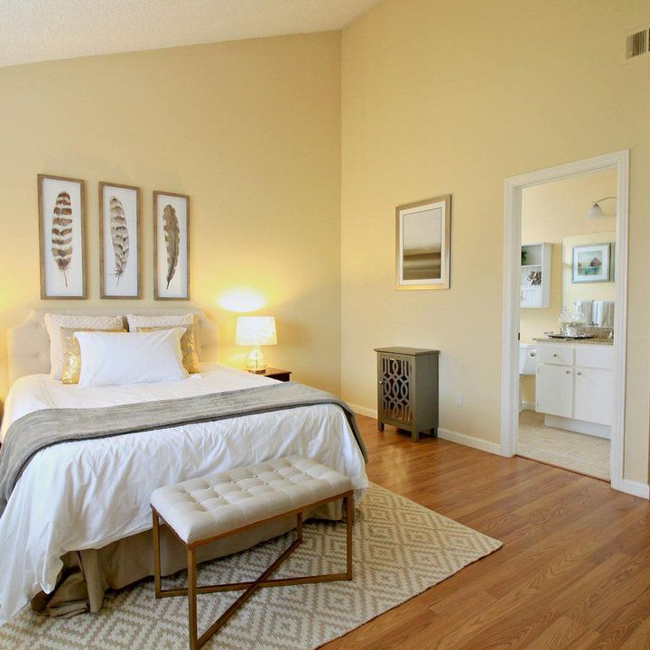 a bed sitting in a bedroom on top of a hard wood floor next to two lamps