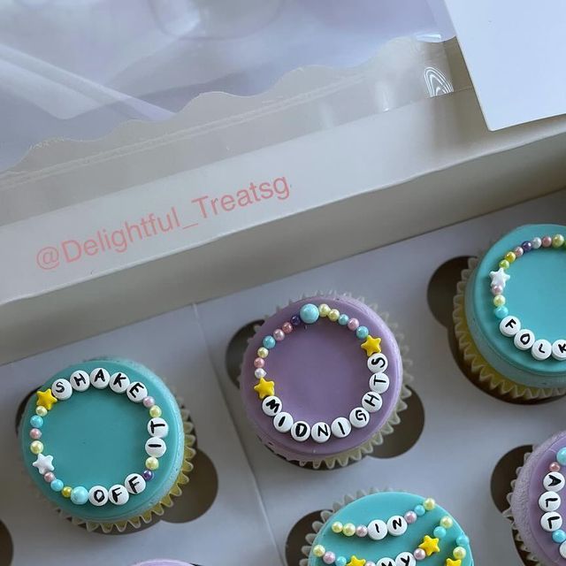 cupcakes decorated with letters and beads in a box