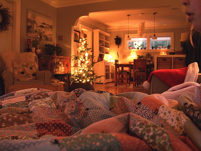 a woman sitting on the floor in front of a christmas tree