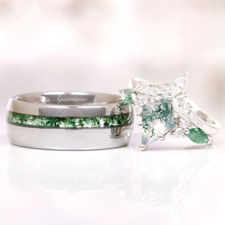 two wedding rings with green and white stones