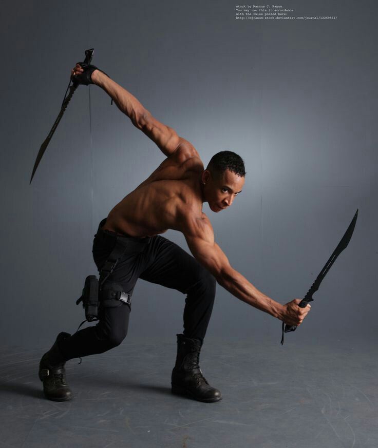 a shirtless man holding two swords in one hand and kneeling down on the other