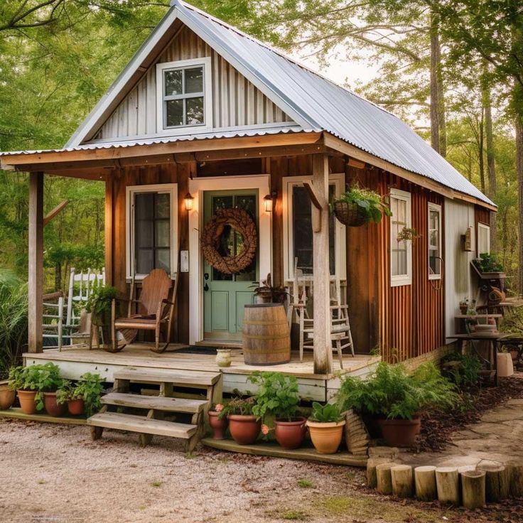 a small house with a porch and steps leading to the front door is surrounded by greenery