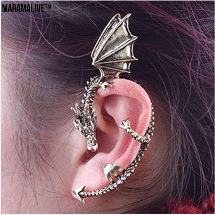 a woman wearing ear piercings with a dragon on it