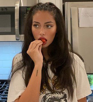 a woman is eating something in the kitchen