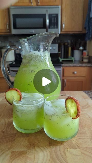 a pitcher and two glasses filled with green liquid