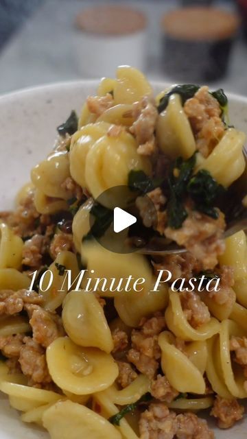 a white bowl filled with pasta and meat