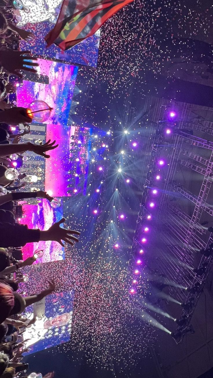 people standing in front of a stage with lights and confetti