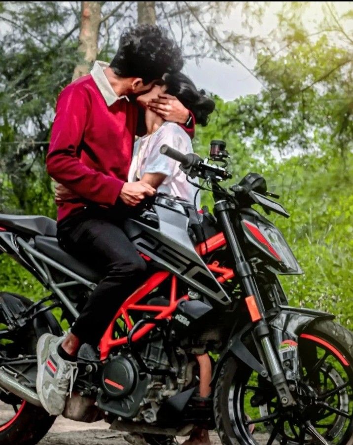 a man and woman are sitting on a motorcycle