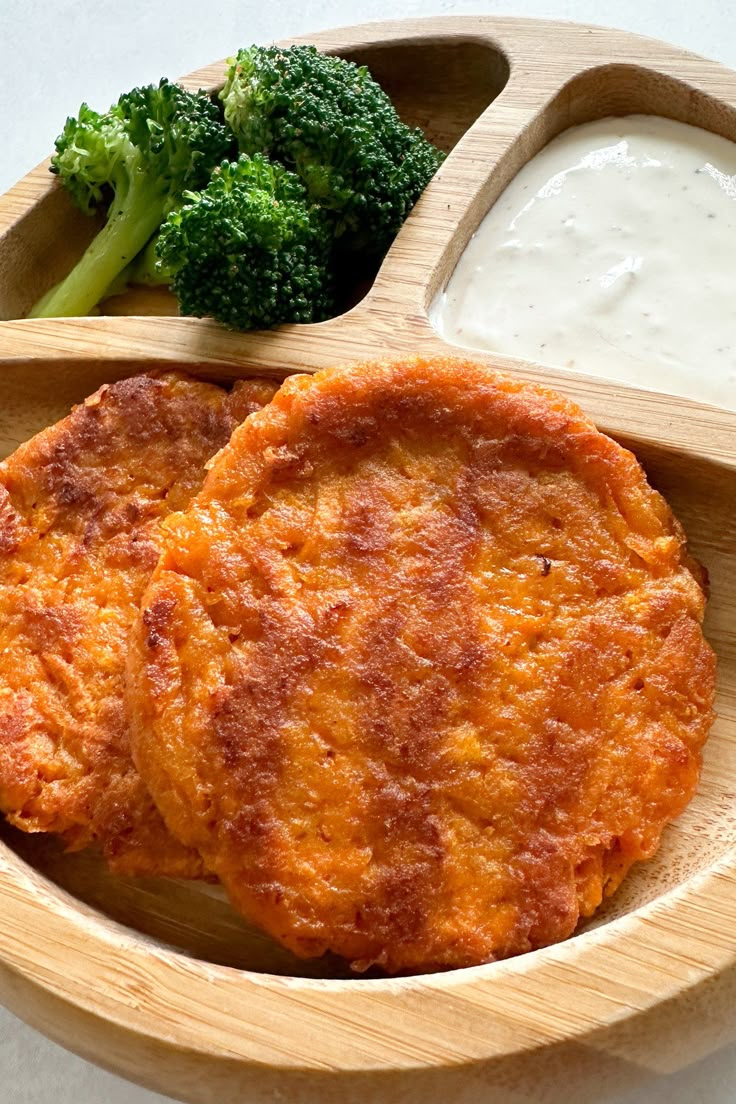 some food is in a wooden bowl with broccoli and ranch dressing on the side