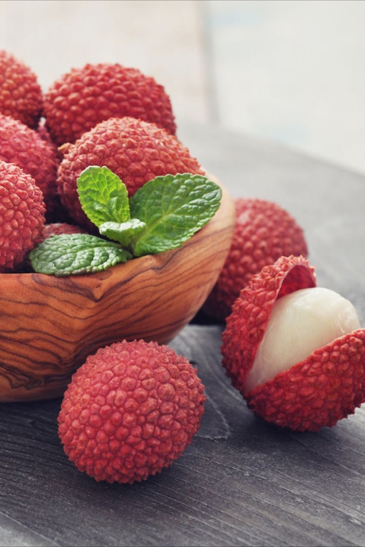 fresh raspberries in a wooden bowl with mint leaves