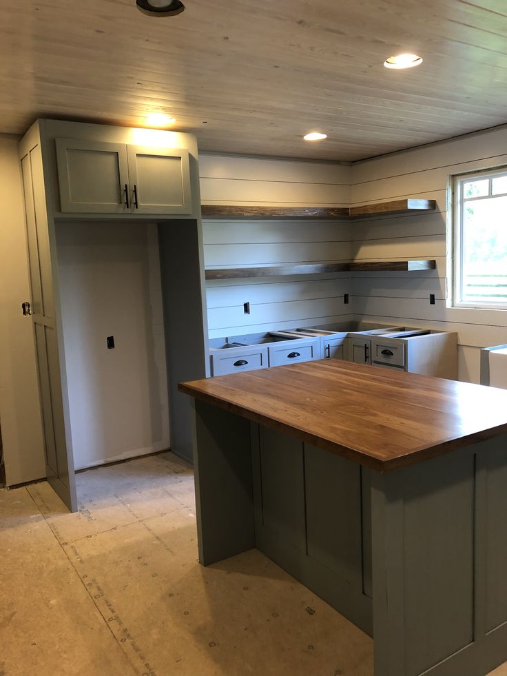 an empty kitchen with wooden counters and cabinets