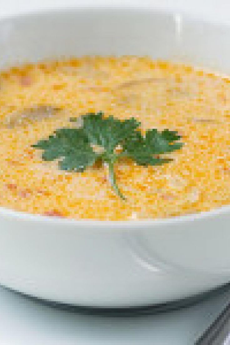 a white bowl filled with soup and garnished with parsley on the side