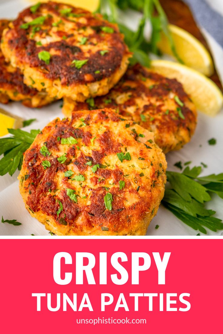 crispy tuna patties on a white plate with lemon wedges and parsley