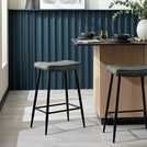 two stools sitting in front of a kitchen counter with a potted plant on it