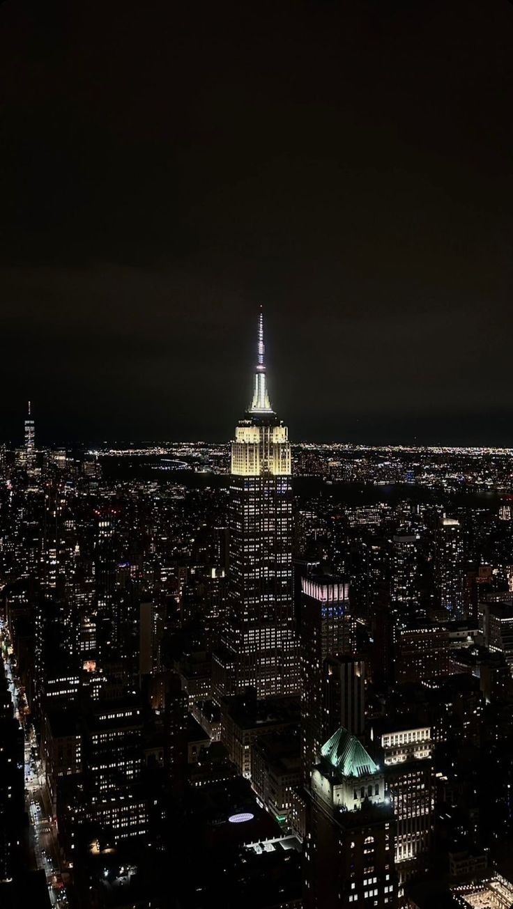 the empire building is lit up at night in new york city, ny with all its lights on