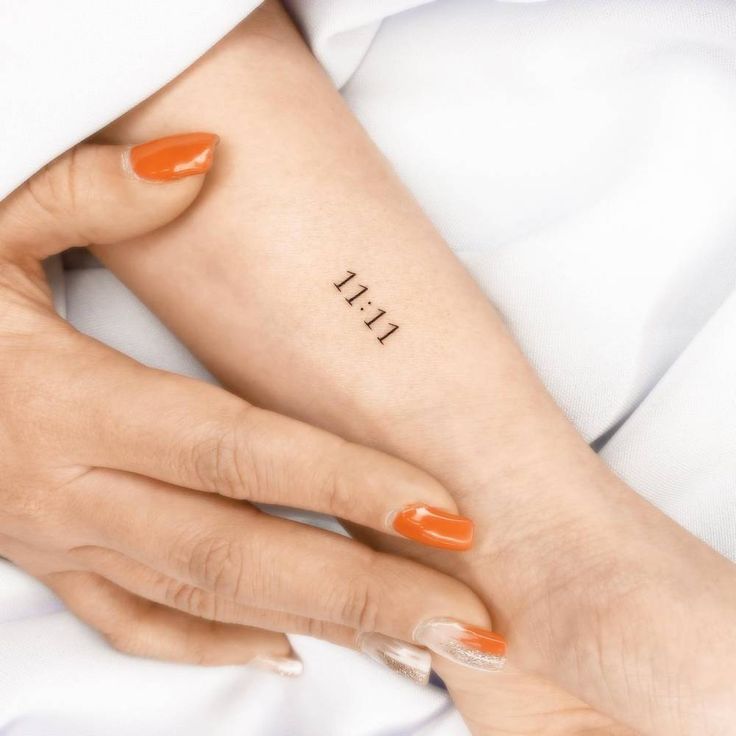 a woman's arm with an orange manicure and the word thii on it