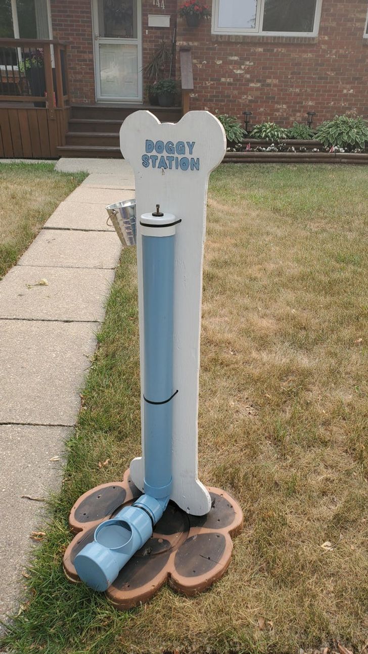 a blue and white water fountain sitting on top of a wooden stump in front of a brick building