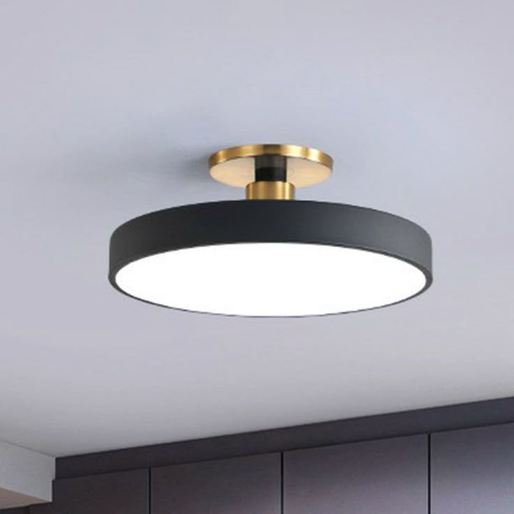 a black and gold circular light fixture in a kitchen