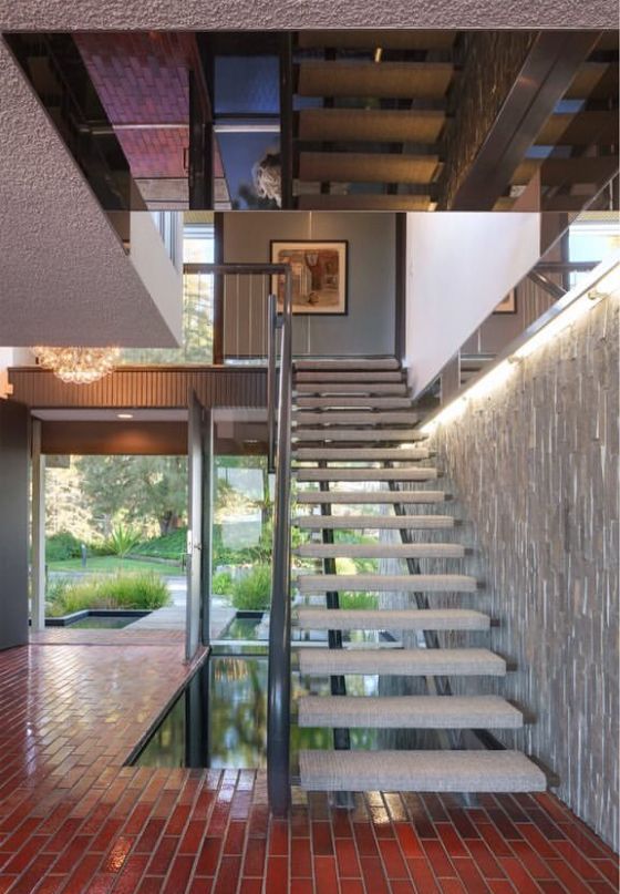 a staircase leading up to the upper level of a house with red tile flooring