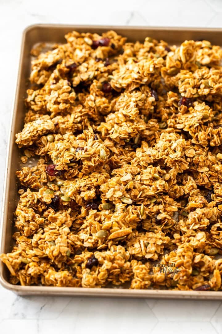 granola clusters in a baking pan with the words honey granola clusters above it