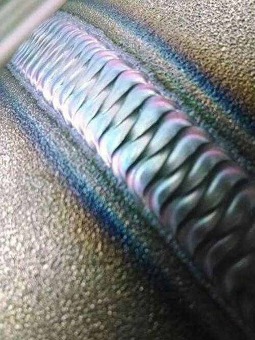 a close up view of the inside of a piece of metal with blue and green stripes