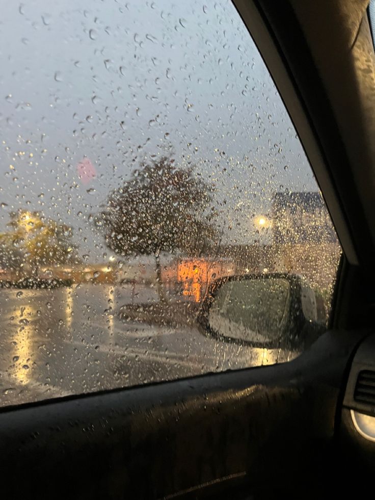 rain is falling on the windshield of a car