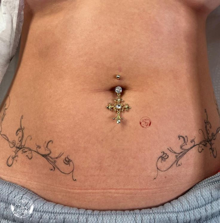 a woman's stomach with a cross tattoo on it