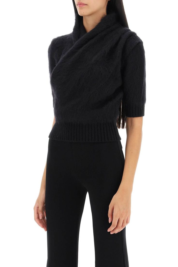 Elevate your style with this stunning draped cropped top in a luxurious black mohair wool blend. The two side crystal buttons add a touch of elegance, while the ribbed trims create a chic and sophisticated look. The slim fit silhouette is designed to flatter your figure, making it the perfect addition to your wardrobe. Whether you're going out for a night on the town or dressing up your everyday look, this top is sure to turn heads. Crafted with attention to detail and quality, this draped cropp Japan Jeans, Black Fr, Surplice Top, Balmain Paris, Mohair Yarn, Pierre Balmain, Women's Wardrobe, French Fashion, Denim Pant