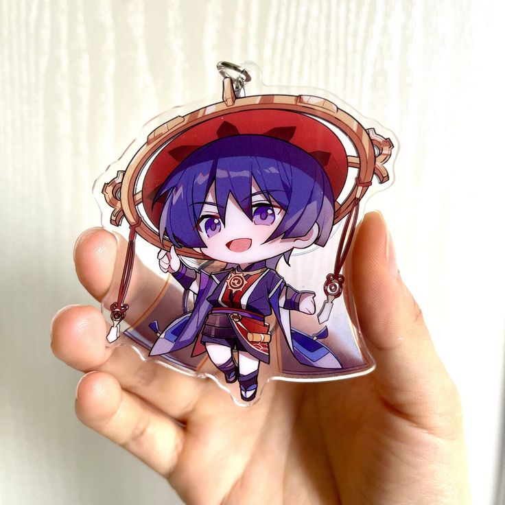 a person holding a keychain with an anime character on it's side