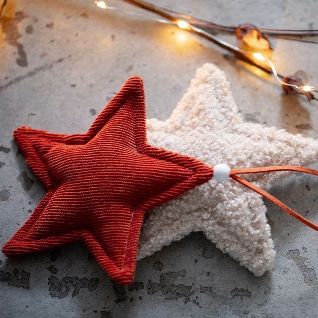 a red and white star ornament sitting on top of a table next to string lights