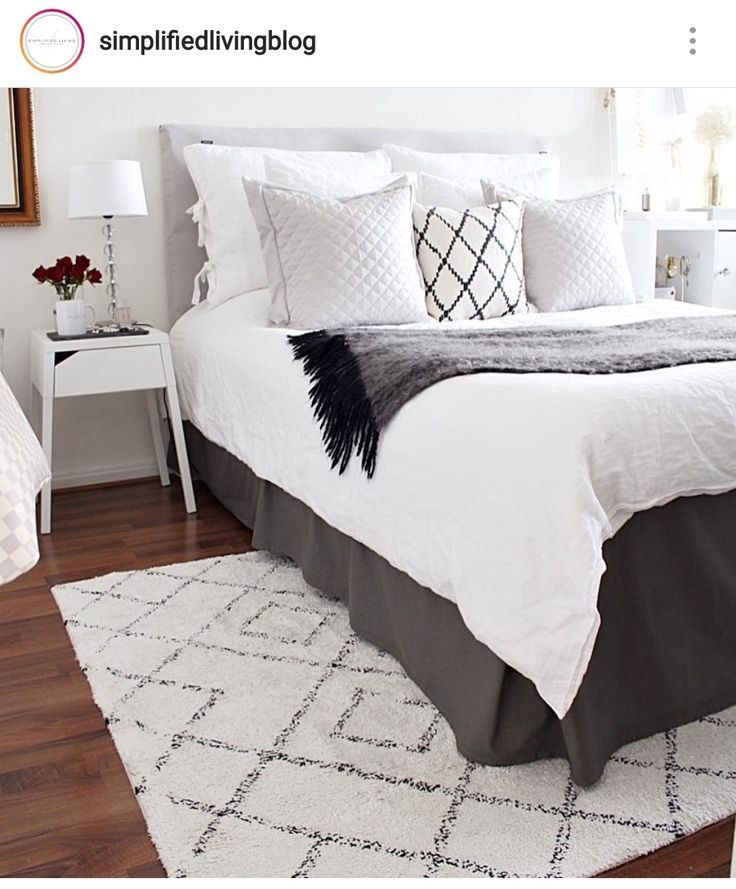 a bed with white sheets and pillows in a bedroom