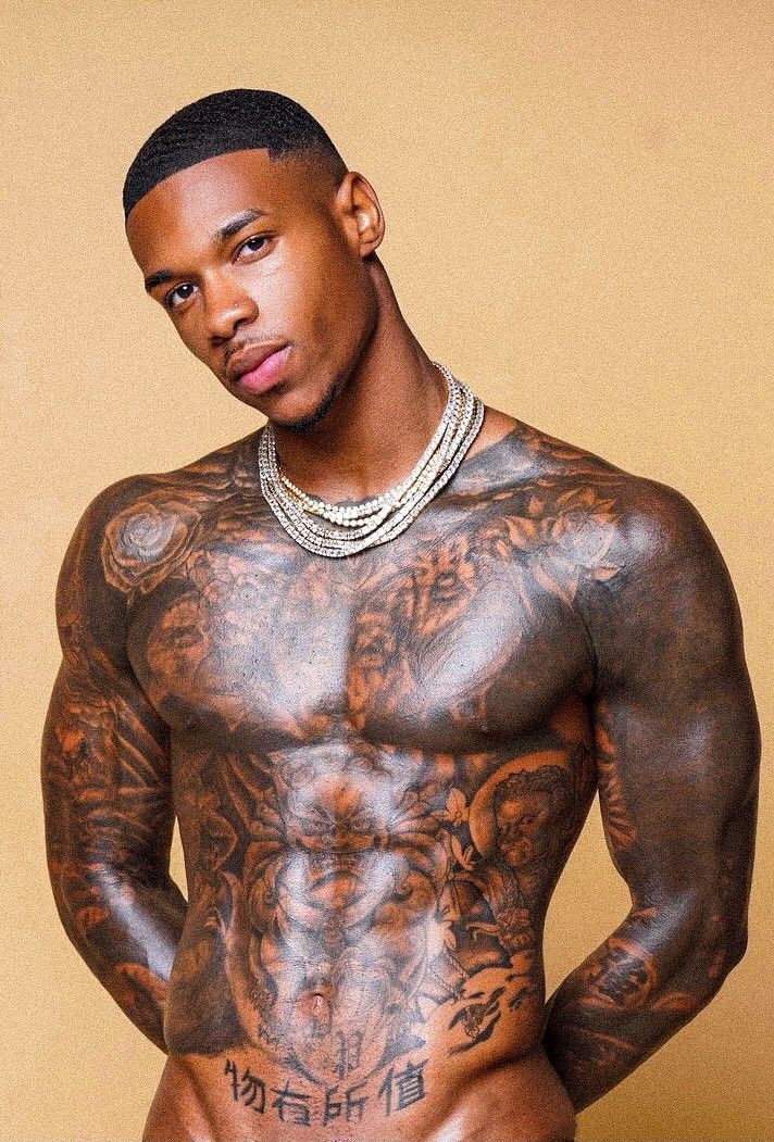 a shirtless man with tattoos on his chest