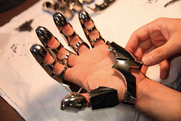 a person is holding out their hand made from metal