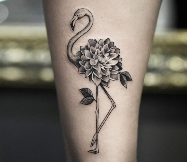 a flamingo with a flower on its leg