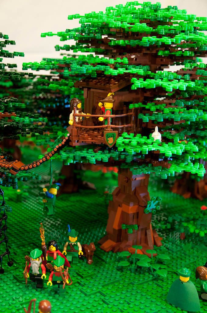 a lego model of a tree house with people on the roof and in the trees