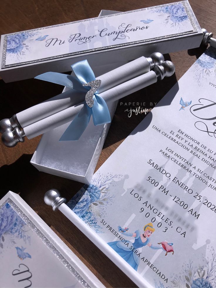 the wedding stationery is decorated with blue and white snowflakes, silver bells, and ribbon