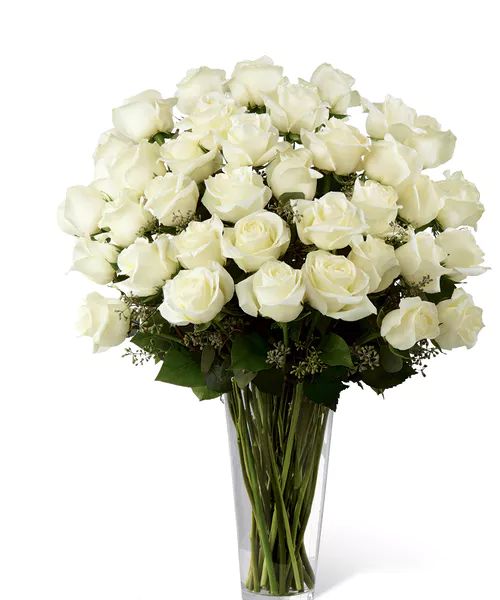 a vase filled with white roses on top of a table