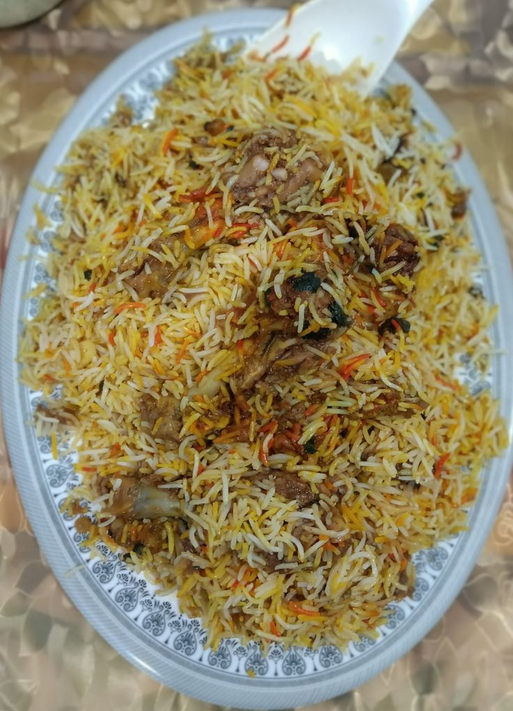 a white plate topped with rice and meat