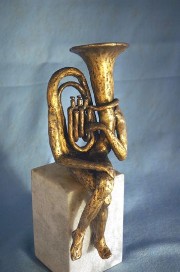 a brass instrument sitting on top of a white block