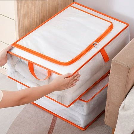 a woman is placing an orange and white suitcase on top of the bed in her living room