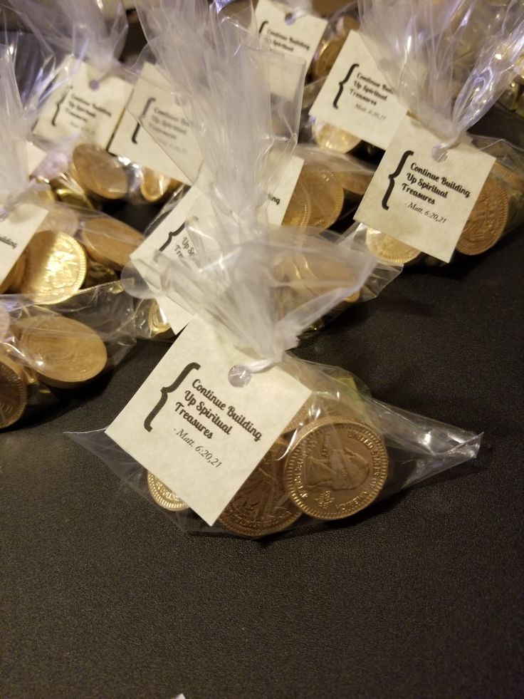 some gold coins are wrapped in plastic and sitting on a table with price tags attached to them