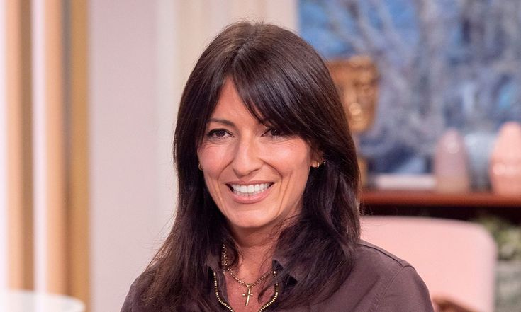 a woman with long hair smiling at the camera