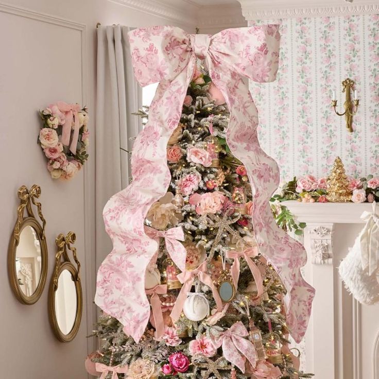 a decorated christmas tree with pink flowers and bows