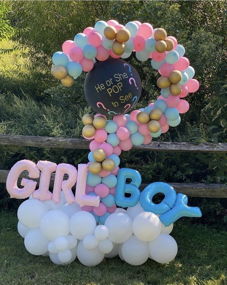 a bunch of balloons that are on top of a sign with the word girl in it