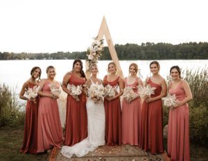 a group of women standing next to each other in front of a body of water