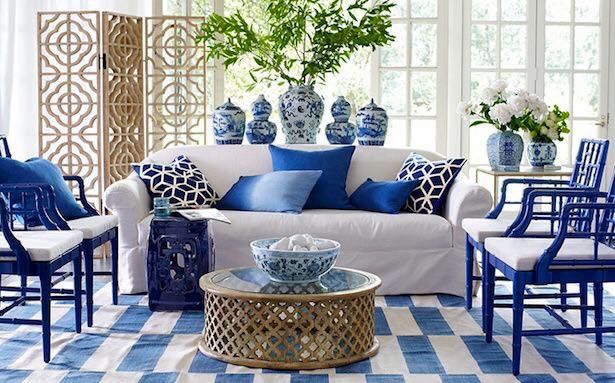 a living room filled with furniture and blue and white decor on top of a checkered floor